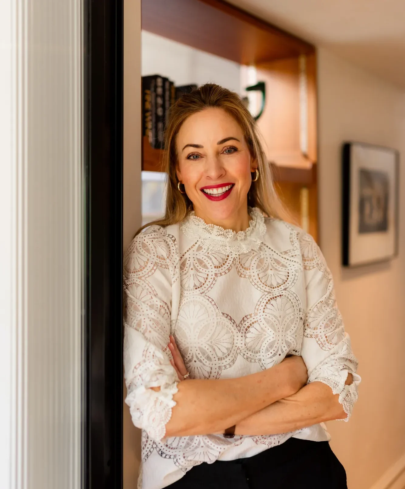 Joanne standing smiling in doorway - used for section Experience meets purpose